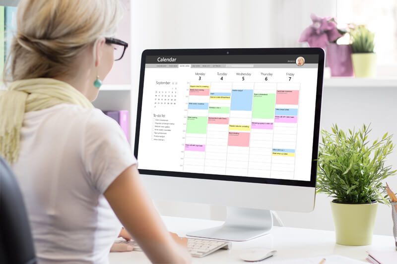 Woman working on a content calendar on her desktop computer