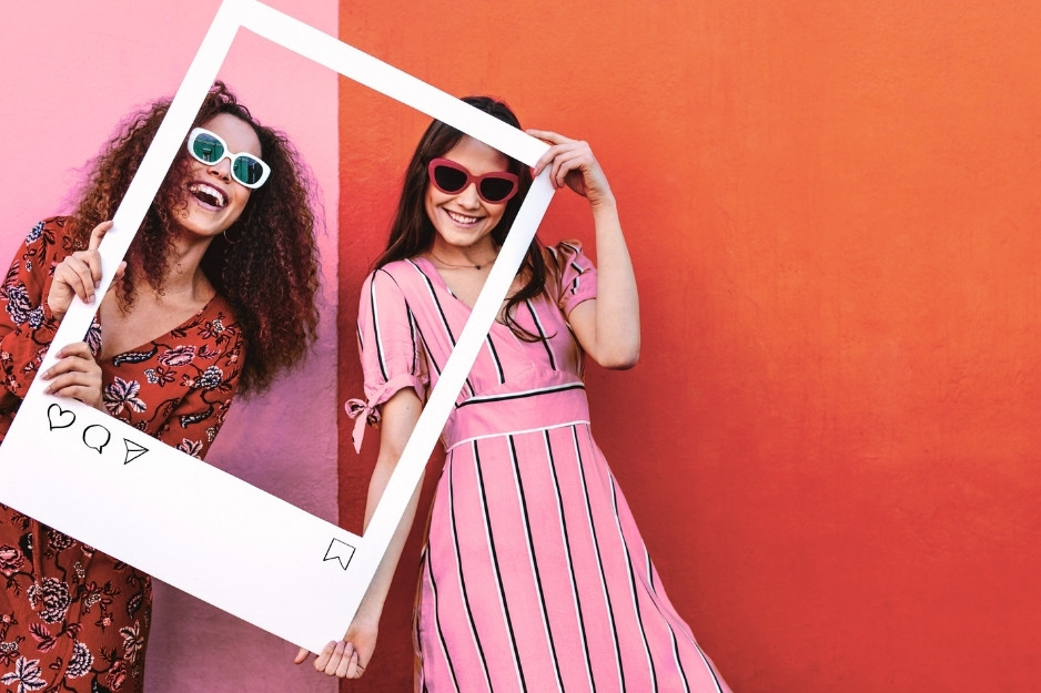 two women with a social media photo prop