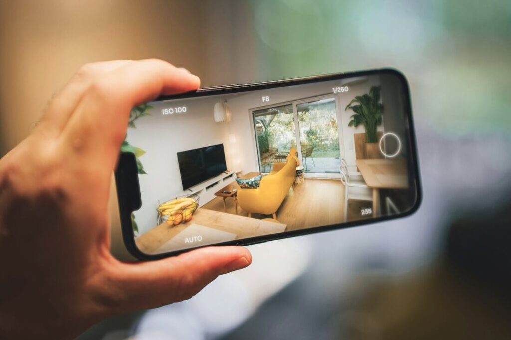 person holding phone watching video of real estate walkthrough video