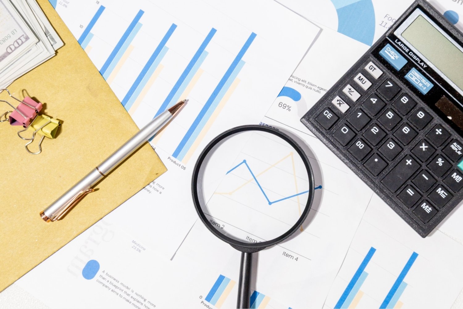 printed statistics on desk with calculator pen and folder